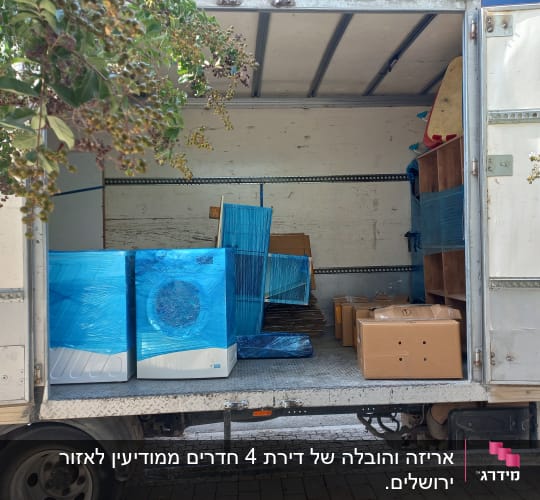 משאית הובלה מועמסת במכשירי חשמל עטופים, ארגזי קרטון וריהוט
